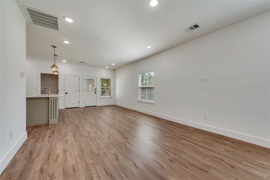 Unfurnished living room with light wood-style floors and recessed lighting Unfurnished living room with light wood-style floors and recessed lighting