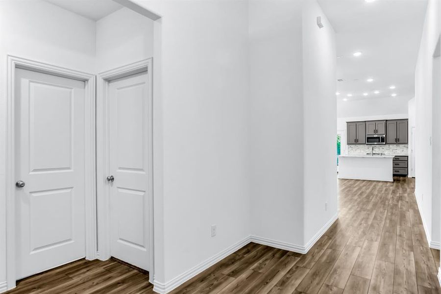 Hallway with wood-finish flooring, recessed lighting, and white baseboards