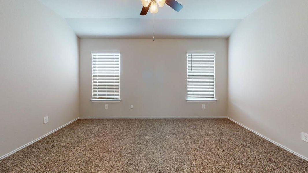 A spacious bedroom features two windows providing ample light and a functional ceiling fan for comfort. A spacious bedroom features two windows providing ample light and a functional ceiling fan for comfort.