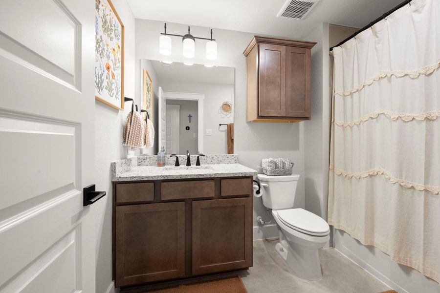 The upstairs secondary bath offers granite countertops and ample cabinetry for storage. The upstairs secondary bath offers granite countertops and ample cabinetry for storage.