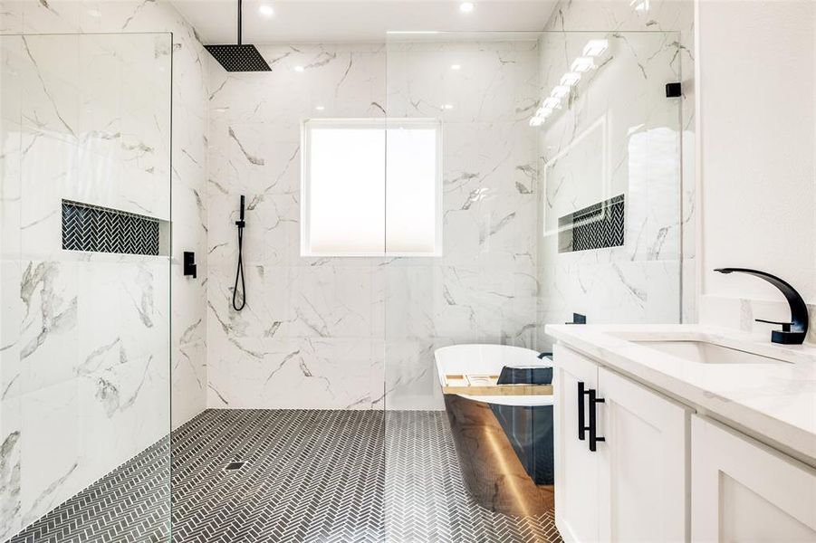 Bathroom with a marble finish shower, vanity, a soaking tub, and recessed lighting Bathroom with a marble finish shower, vanity, a soaking tub, and recessed lighting