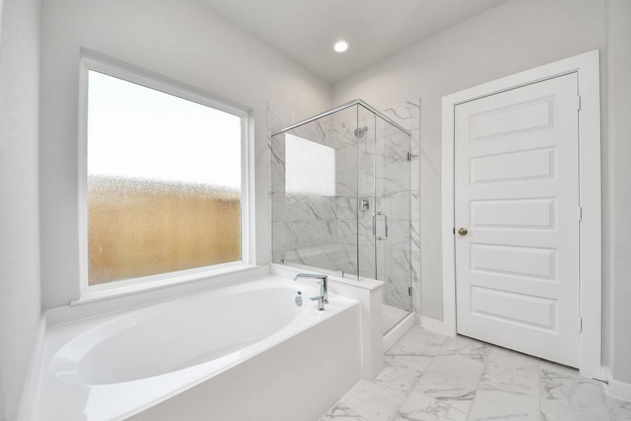 Unwind in a separate garden tub adorned with custom detailing. Unwind in a separate garden tub adorned with custom detailing.