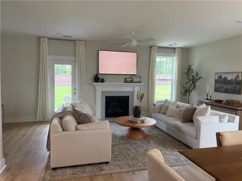 Hardwood floors and a classic fireplace anchor thi