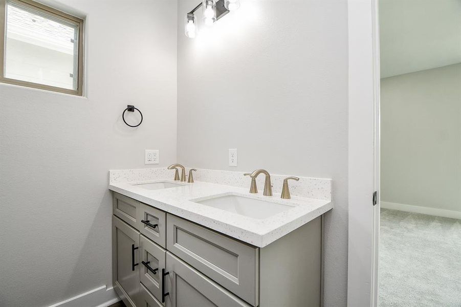 This is a modern, well-lit Master bathroom featuring a double vanity with ample storage and elegant fixtures, set against a neutral color palette, perfect for personalizing to your taste.