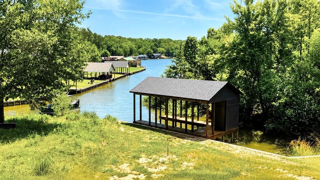 Newly constructed boat house featuring a dark-toned exterior, gabled roof, and covered slip