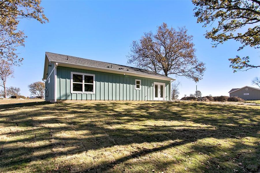 Back of house with a yard and french doors