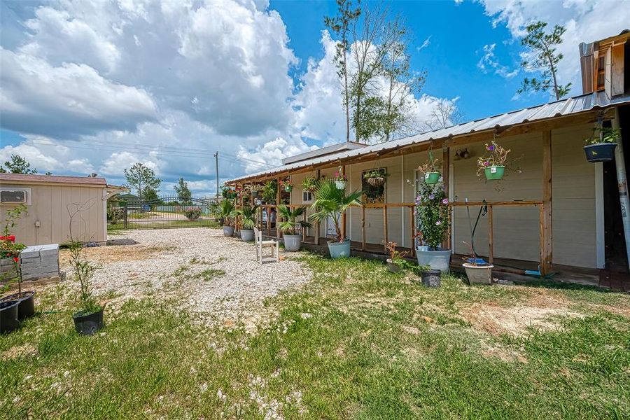 The charming small house, complete with a cozy shed and a vibrant garden, creates a tranquil oasis that invites relaxation and simple living amidst nature's beauty.