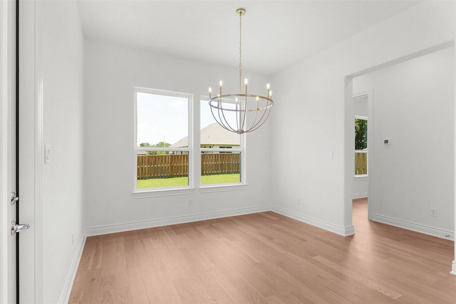 Room featuring light wood-finish flooring and a contemporary chandelier