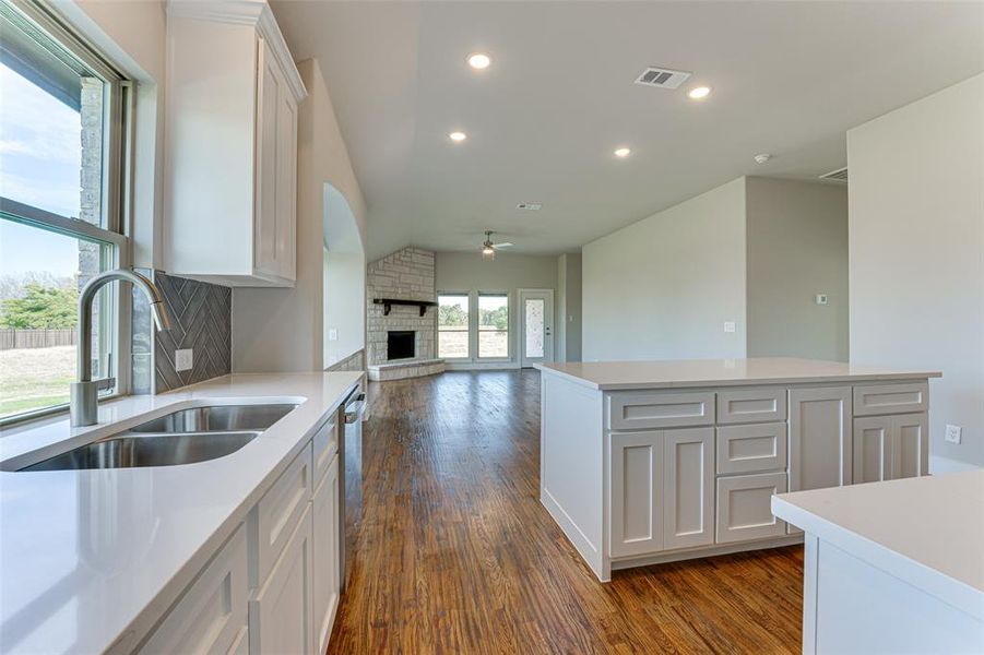 Kitchen featuring ceiling fan, a center island, sink, dark hardwood / wood-style floors, and white cabinets