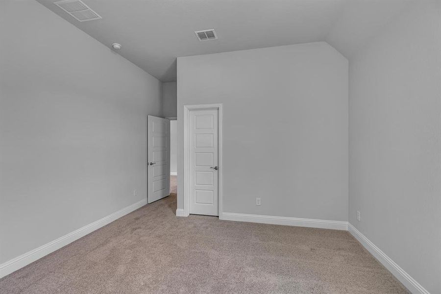 Unfurnished bedroom with lofted ceiling and light carpet