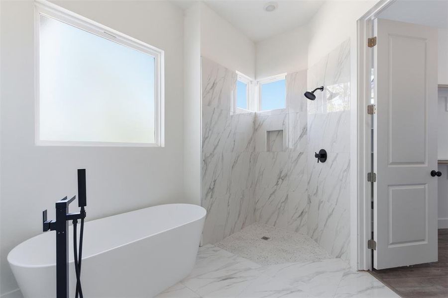 Bathroom featuring a soaking tub, a marble finish shower, and marble finish floors Bathroom featuring a soaking tub, a marble finish shower, and marble finish floors