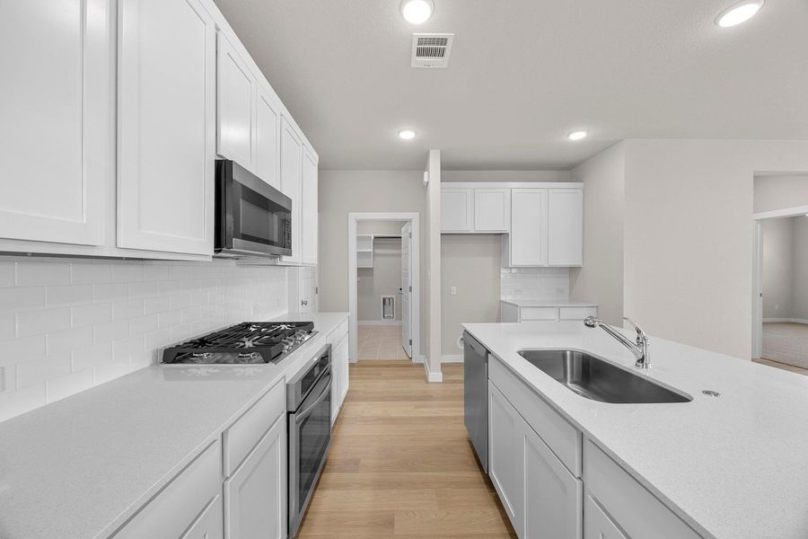 Modern kitchen with sleek white cabinetry, gleaming countertops, and integrated appliances awaits culinary adventures. Modern kitchen with sleek white cabinetry, gleaming countertops, and integrated appliances awaits culinary adventures.