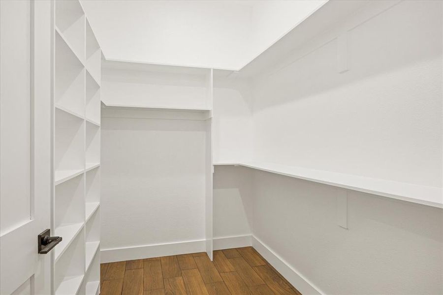 Spacious closet with dark wood-style flooring Spacious closet with dark wood-style flooring