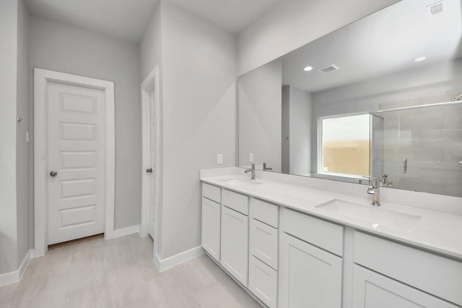 Escape to a spa-like oasis in this primary bathroom. Enjoy a walk-in shower with tile surround, a separate garden tub with custom detailing, and an elegant vanity featuring light countertops, modern hardware, and beautiful vanity lights. Experience luxury and relaxation in every detail.