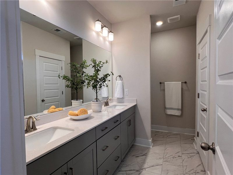 This spacious bathroom offers a double vanity and This spacious bathroom offers a double vanity and