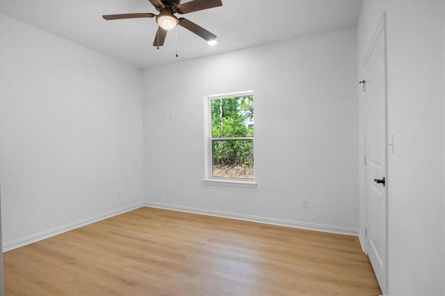 Spare room with light wood-type flooring and ceiling fan
