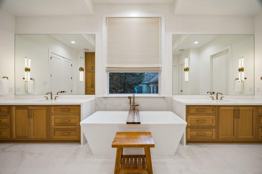 The primary bathroom showcases beautiful finishes, featuring a generously sized shower and a luxurious freestanding soaking tub.
