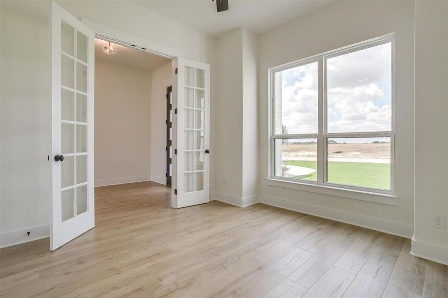 Spare room featuring light hardwood / wood-style flooring and french doors