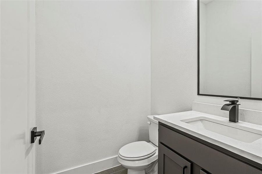 Bathroom featuring vanity and a textured wall Bathroom featuring vanity and a textured wall