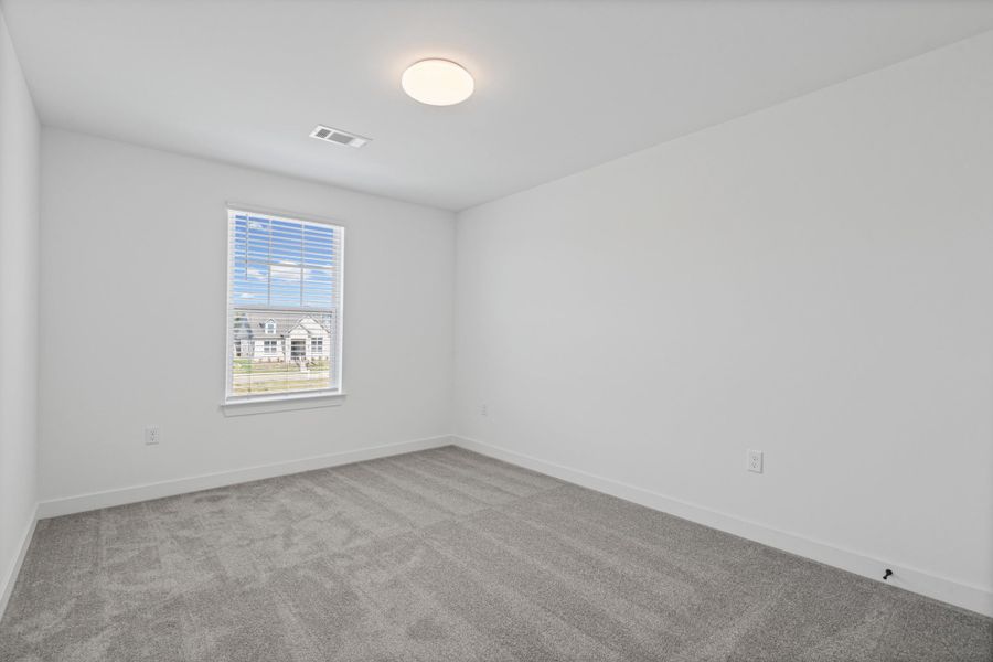 Neutral color palette throughout, featuring light gray carpeting and white walls