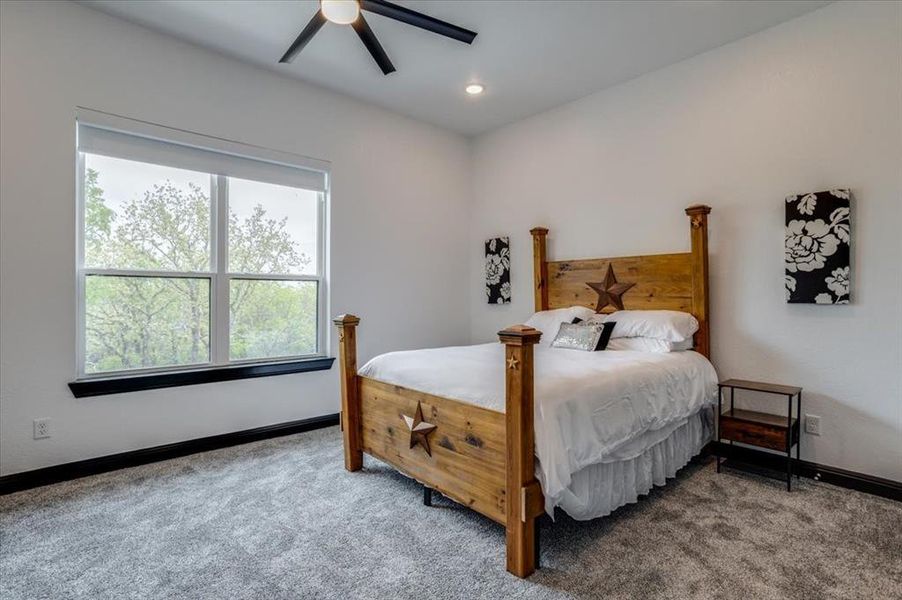 Carpeted bedroom with a ceiling fan and recessed lighting