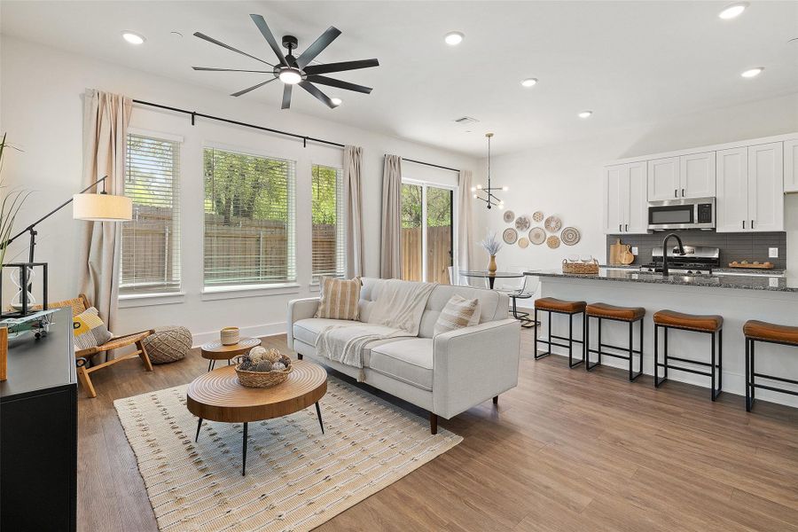 Living area featuring recessed lighting, wood finished floors, ceiling fan, and a chandelier Living area featuring recessed lighting, wood finished floors, ceiling fan, and a chandelier