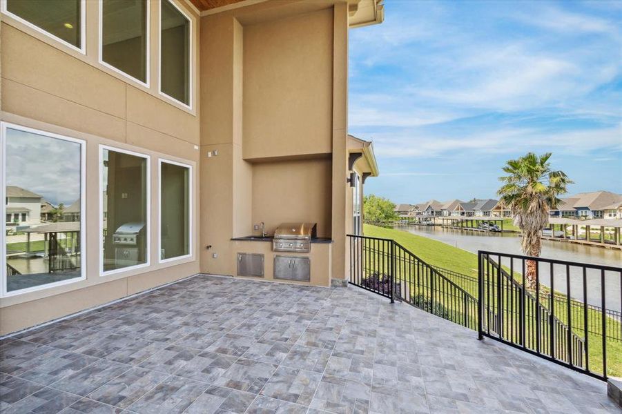 Outdoor kitchen with an open layout, a serene patio vista.