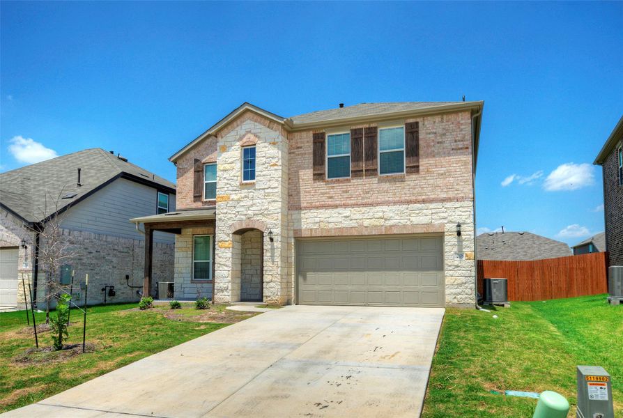 An inviting front entry welcomes you to this two-story residence with a stone and brick façade, featuring a spacious attached garage and a concrete driveway. An inviting front entry welcomes you to this two-story residence with a stone and brick façade, featuring a spacious attached garage and a concrete driveway.