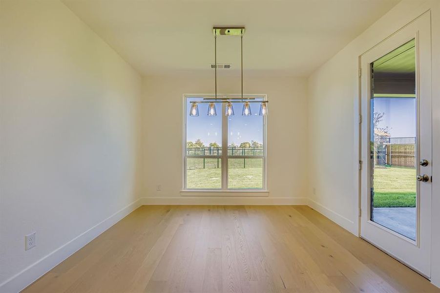 Unfurnished dining area featuring light wood-style floors and baseboards