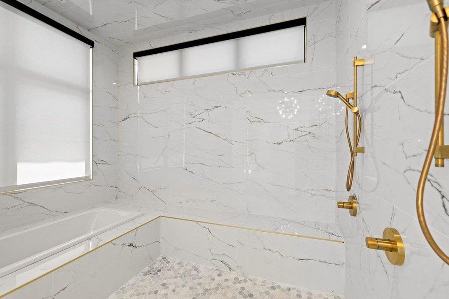 Marble-clad walls and a spacious tub create a luxurious bathroom retreat.