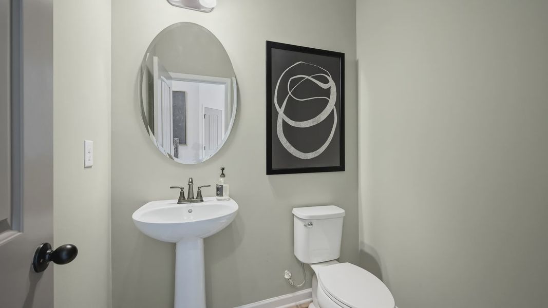 Elegant half bath with pedestal sink and modern fixtures in Langley Overlook townhome in Loganville, Georgia. Elegant half bath with pedestal sink and modern fixtures in Langley Overlook townhome in Loganville, Georgia.