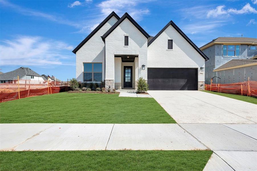 Modern farmhouse style home with brick siding, concrete driveway, and stone siding Modern farmhouse style home with brick siding, concrete driveway, and stone siding