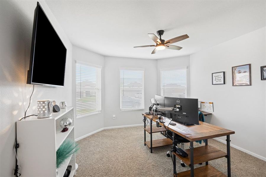 Bedroom currently used as Home office featuring light carpet and ceiling fan