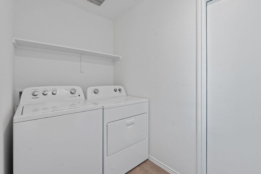 Washroom with washer and clothes dryer and wood finished floors