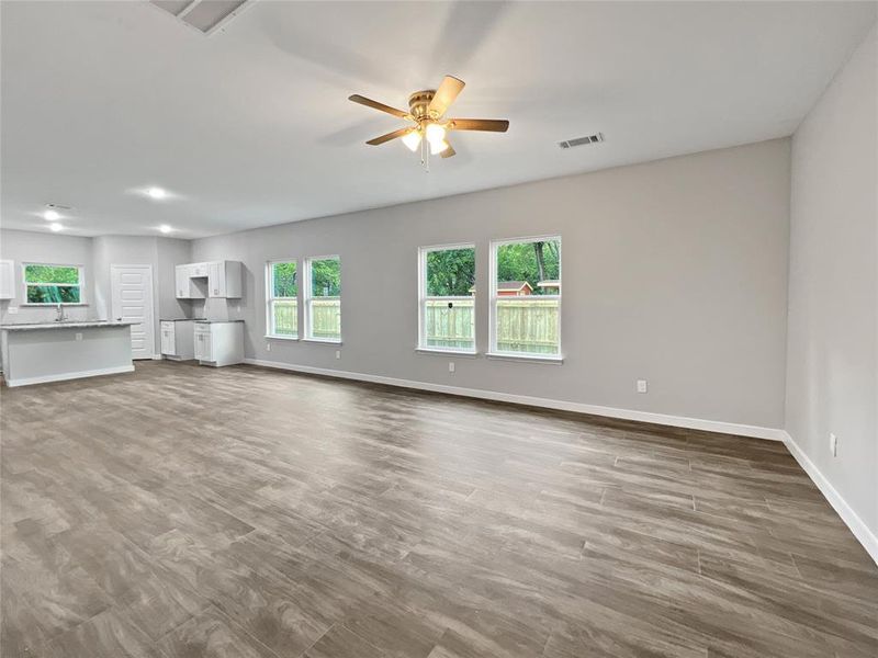 Unfurnished living room with ceiling fan and dark hardwood / wood-style floors