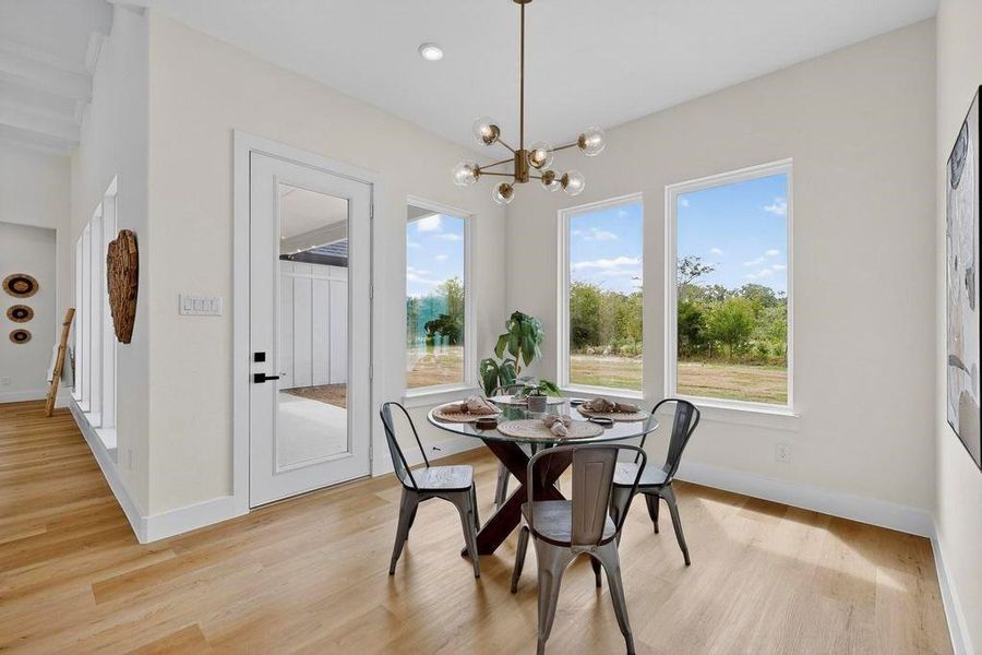 Dining space with light wood finished floors, a chandelier, and recessed lighting Dining space with light wood finished floors, a chandelier, and recessed lighting