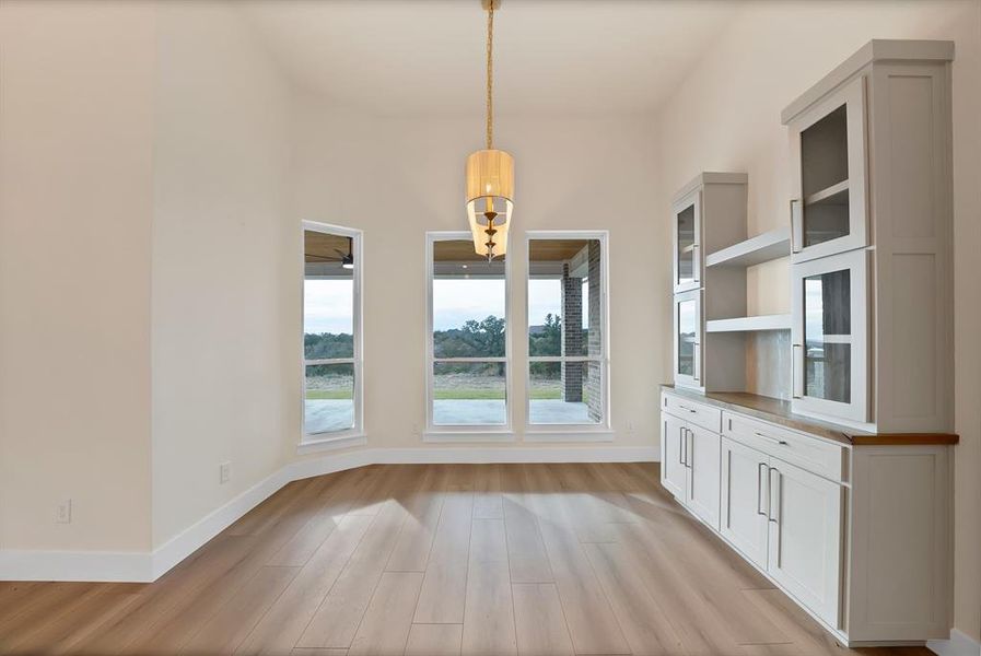 Unfurnished dining area with light wood-style flooring and baseboards Unfurnished dining area with light wood-style flooring and baseboards