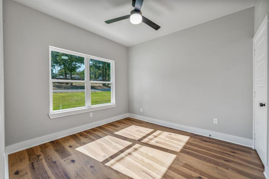 Empty room with wood finished floors and ceiling fan Empty room with wood finished floors and ceiling fan
