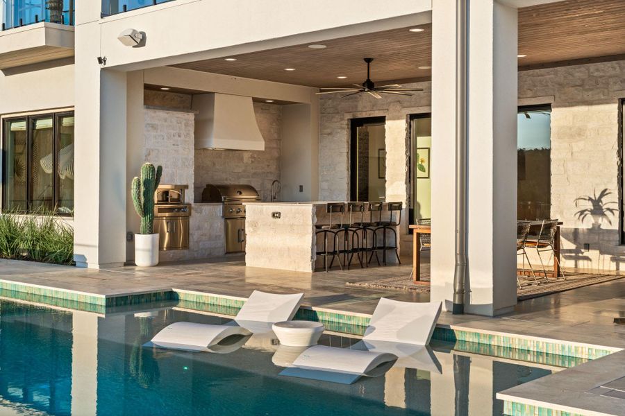 Swimming pool featuring exterior kitchen, a patio, and a ceiling fan Swimming pool featuring exterior kitchen, a patio, and a ceiling fan