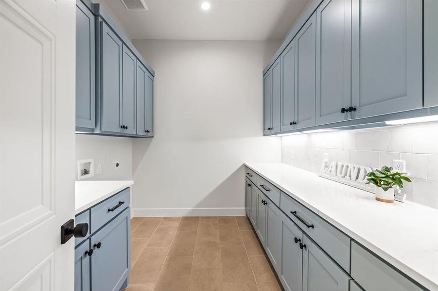 Laundry Room Featuring Custom Storage Including a Broom and Vacuum Closet with Power