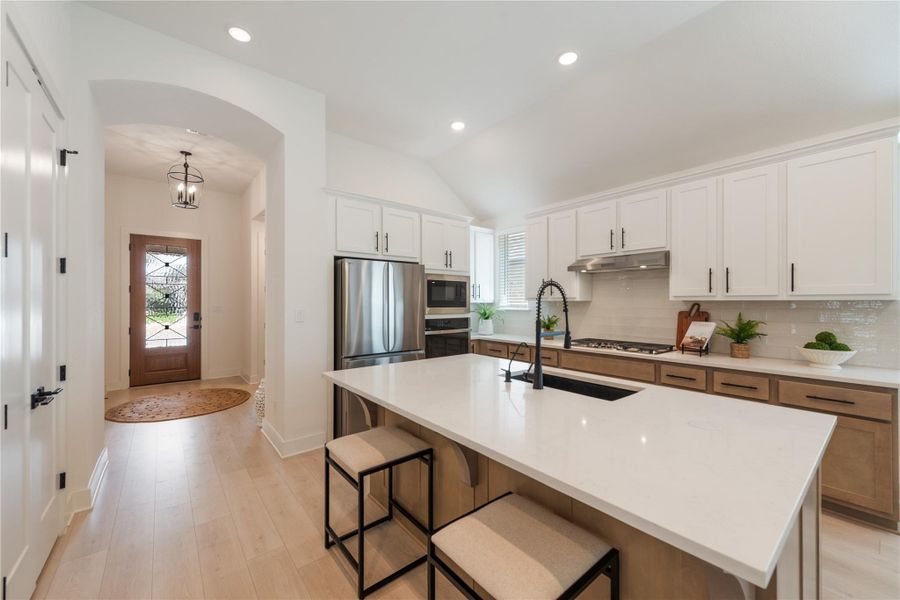 Culinary aspirations find their home in this kitchen, boasting pristine white countertops and modern stainless steel appliances. Culinary aspirations find their home in this kitchen, boasting pristine white countertops and modern stainless steel appliances.