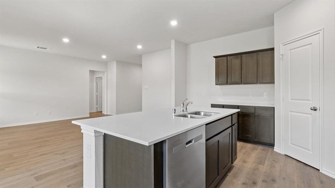 Kitchen featuring a center island with double basin stainless steel sink and integrated dishwasher