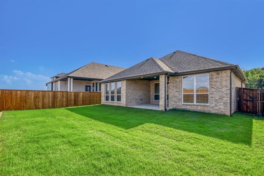 Expansive green lawn with a privacy fence