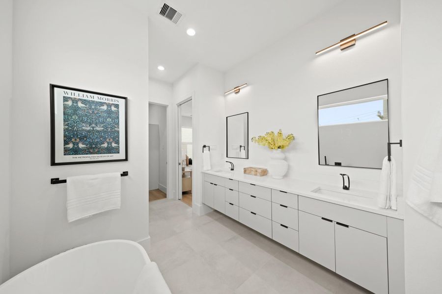 Another view of the luxurious primary bath which includes a private water closet with a storage cabinet. Another view of the luxurious primary bath which includes a private water closet with a storage cabinet.