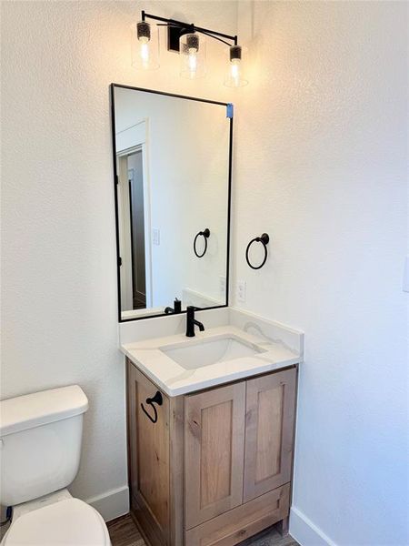 Bathroom with toilet, baseboards, and vanity