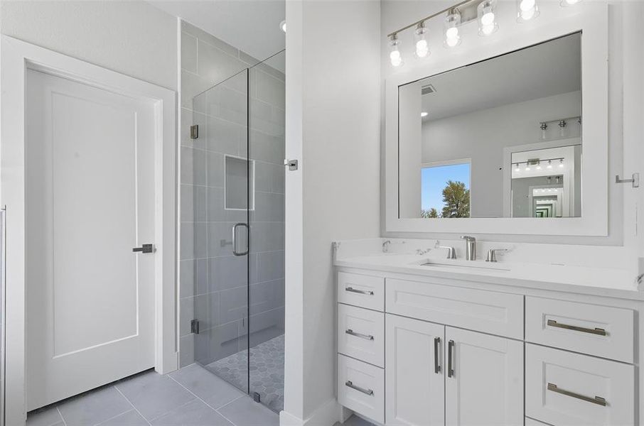 Full bath featuring a shower stall, vanity, and light tile patterned flooring Full bath featuring a shower stall, vanity, and light tile patterned flooring