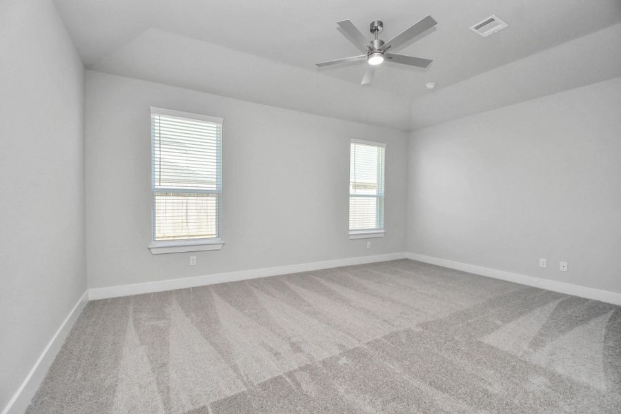 Retreat to the luxurious primary suite, your perfect escape for unwinding after a long day. Located on the first floor, this spacious room features plush carpeting, calming paint tones, high ceilings, and large windows with privacy blinds.