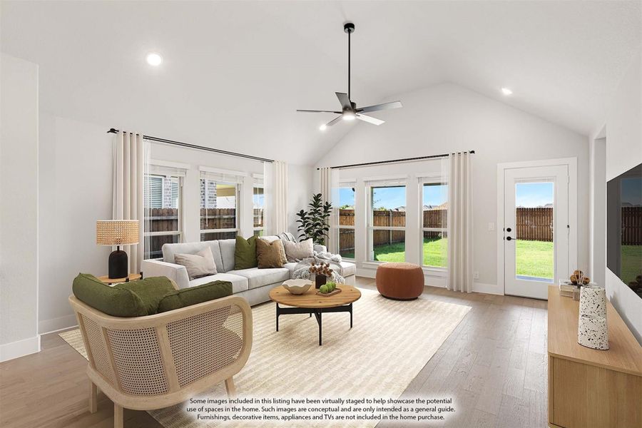 Living room with vaulted ceiling, ceiling fan, hardwood floors, and glass doors leading to backyard.
