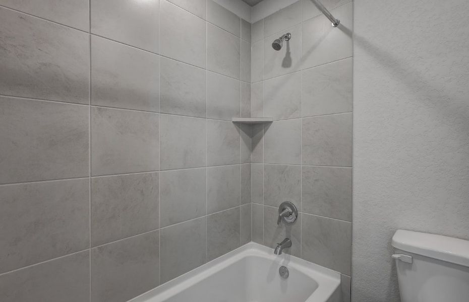 A bathroom with a bathtub and toilet.