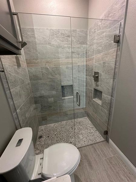 Full bath featuring a shower stall and wood finished floors
